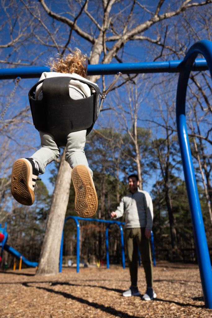 swinging on the playground - what to do during a candid family photo session this spring in Raleigh NC
