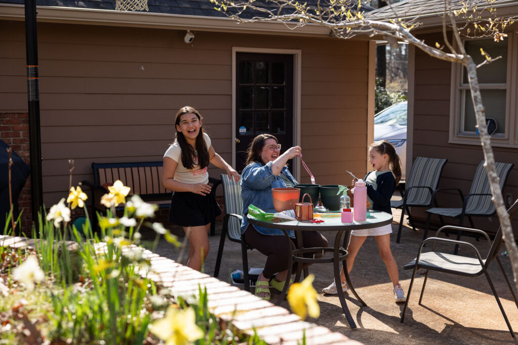 Springtime candid documentary family photos in Raleigh, mom laughing with her daughters