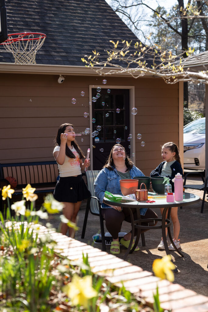 Springtime Candid Documentary Family Photos in Raleigh mom & daughters blowing bubbles 