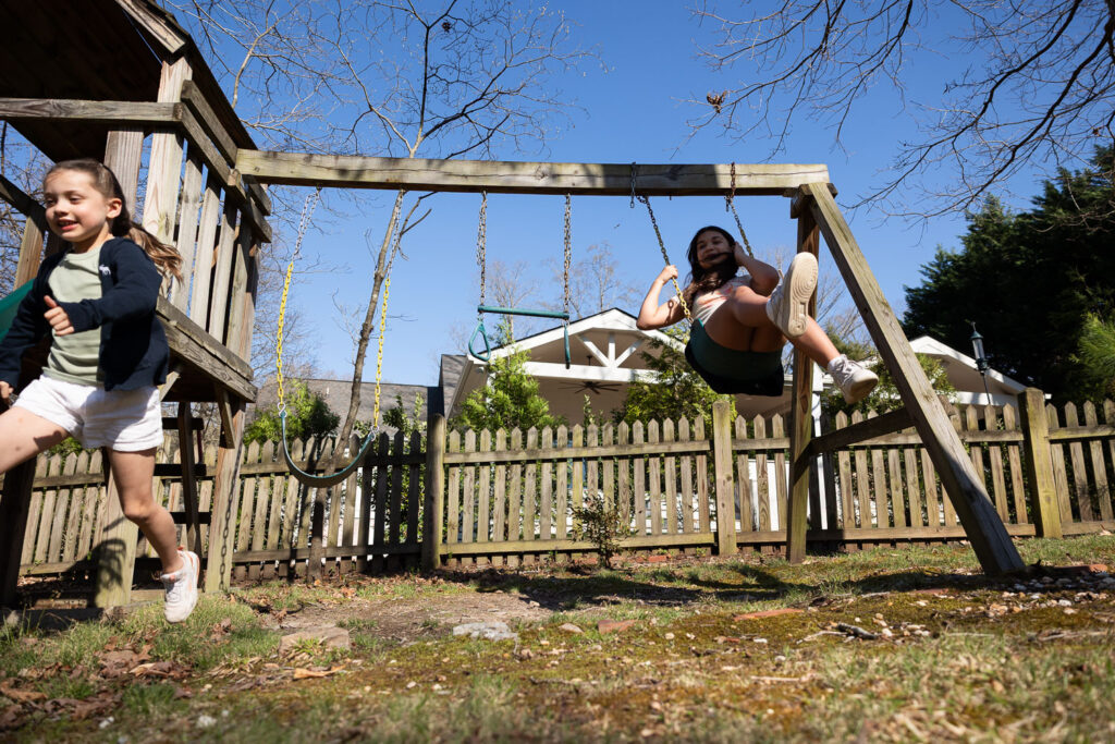 Backyard play on the swingset family photojournalism candid photo session in the spring