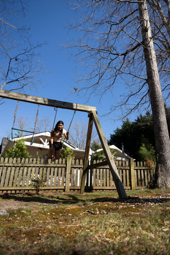 Springtime Candid Documentary Family Photos in Raleigh, jumping off a swing in the backyard