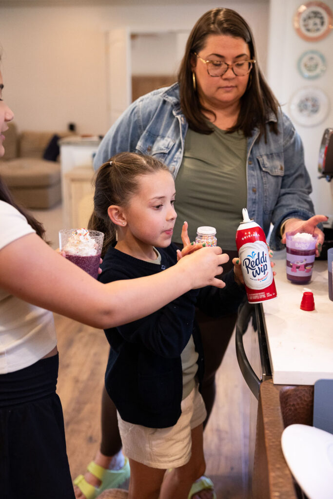 Springtime Candid Documentary Family Photos in Raleigh adding sprinkles and whipped cream to smoothies