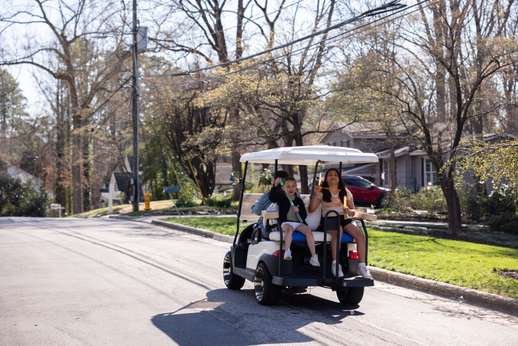 Candid documentary family photo session with golf cart in North Hills neighborhood Raleigh