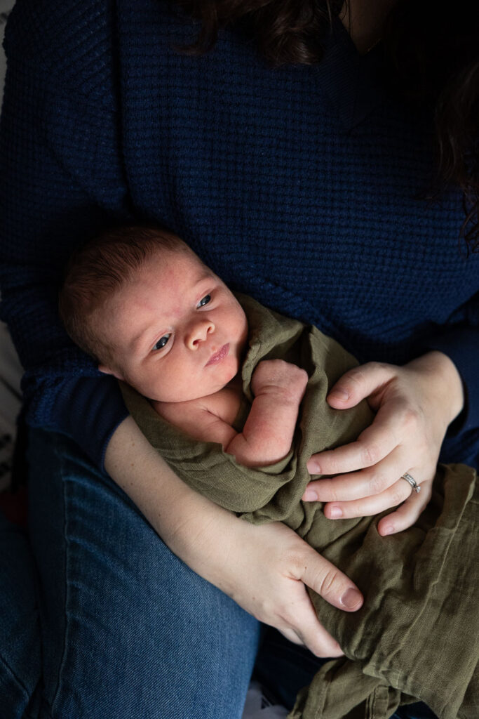 Raleigh natural newborn photos at home with baby in loose green swaddle blanket