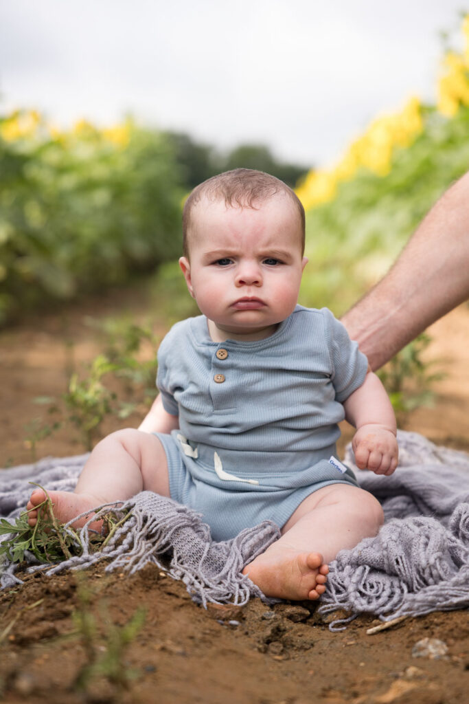 3-month-old baby boy scowls at camera at Dix Park sunflower field photo session