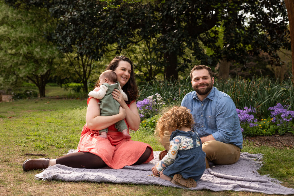 Family playing together during playful Fred Fletcher Park family photo session with toddler and baby