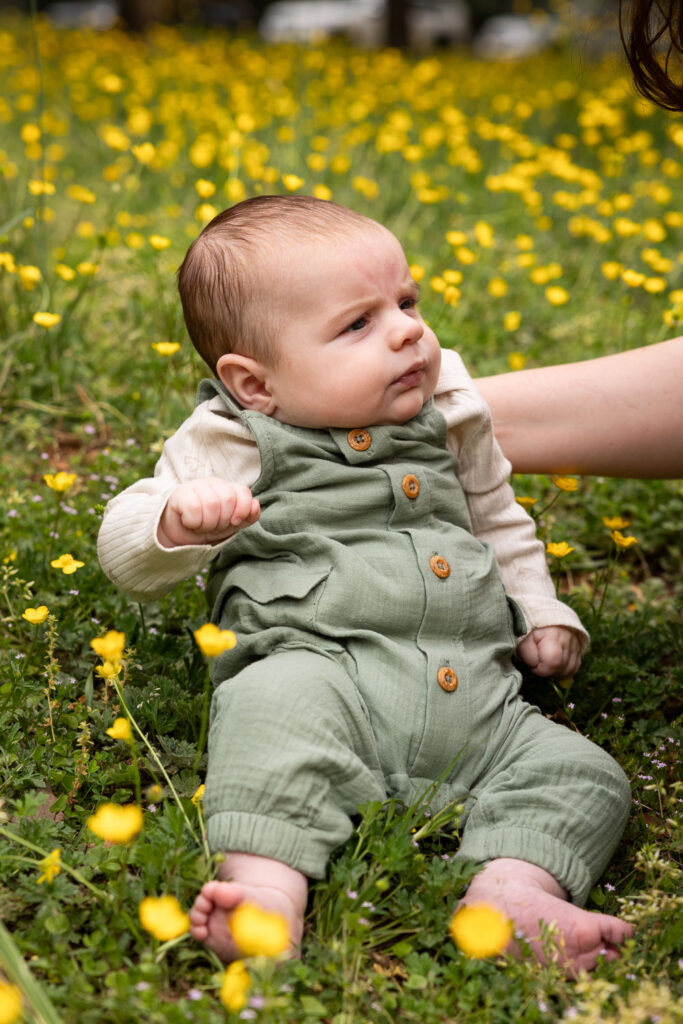 Natural photos for baby's first year in Raleigh, baby boy sits supported in a field of yellow flowers