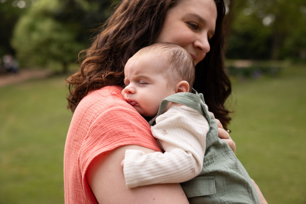 Baby boy sleeps as he's held by mom during Raleigh baby photo session