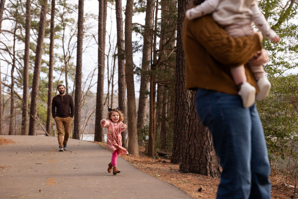 Toddler runs toward mom and brother at Lake Johnson Raleigh family photo session