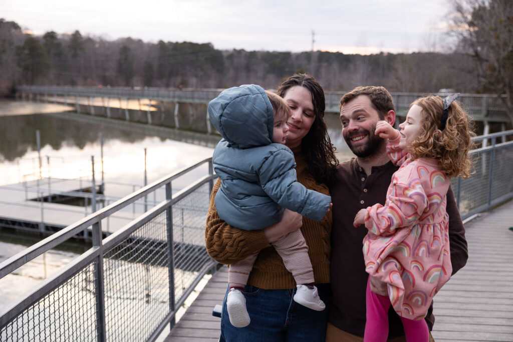 Baby milestone photo sessions in Raleigh, NC celebrating 1-year-old baby boy, family of four at Lake Johnson Raleigh