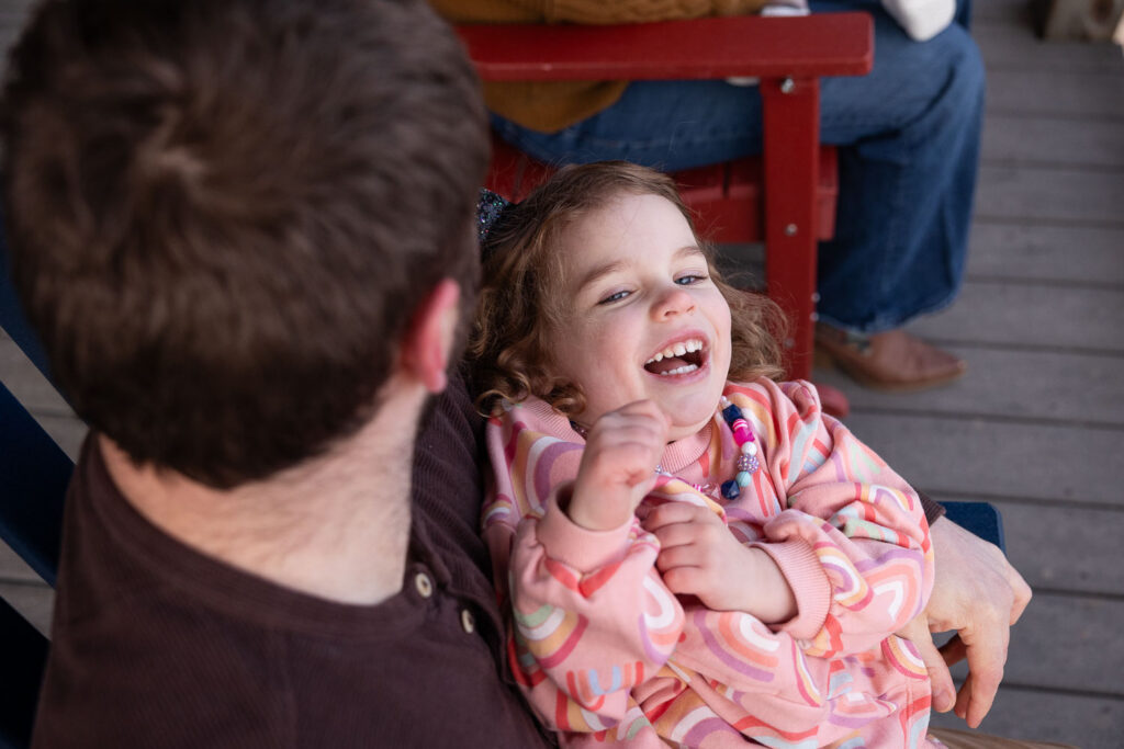 Toddler girl laughing during family photo session at Lake Johnson
