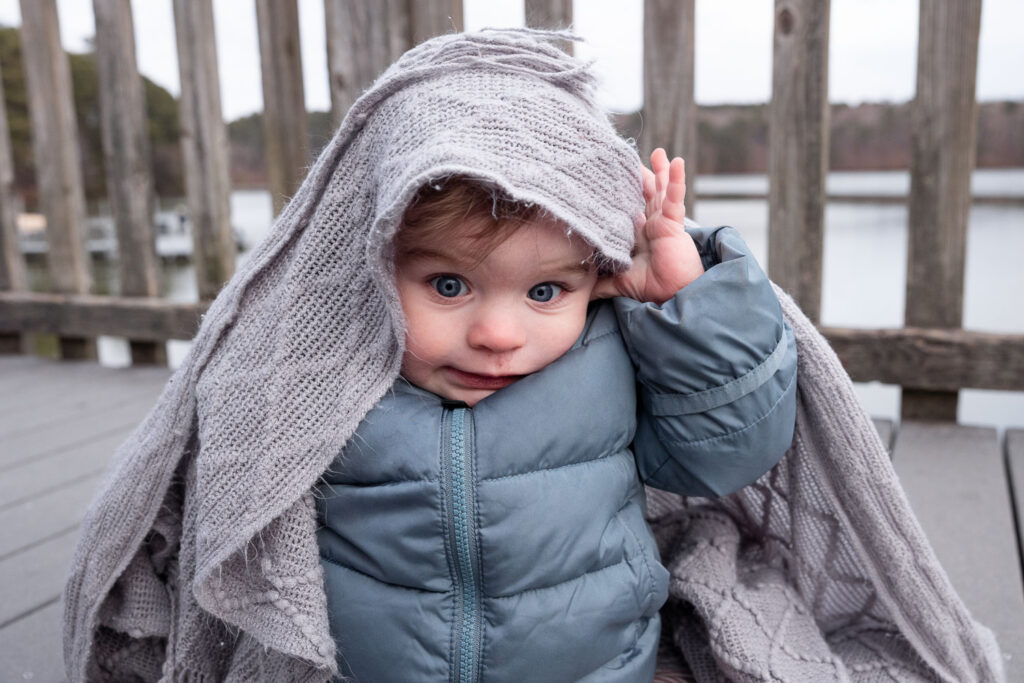 Lake Johnson bridge, 1-year-old sits with blanket over his head during baby and family photo session 