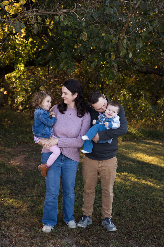 Prairie Ridge Ecostation family photo session with yearlong photo collection, Raleigh family of four stands and laughs together