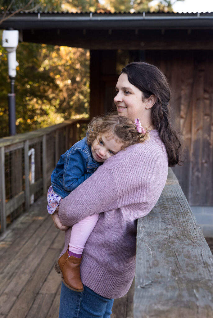 Mom and toddler daughter snuggle together at Prairie Ridge Ecostation family photo session