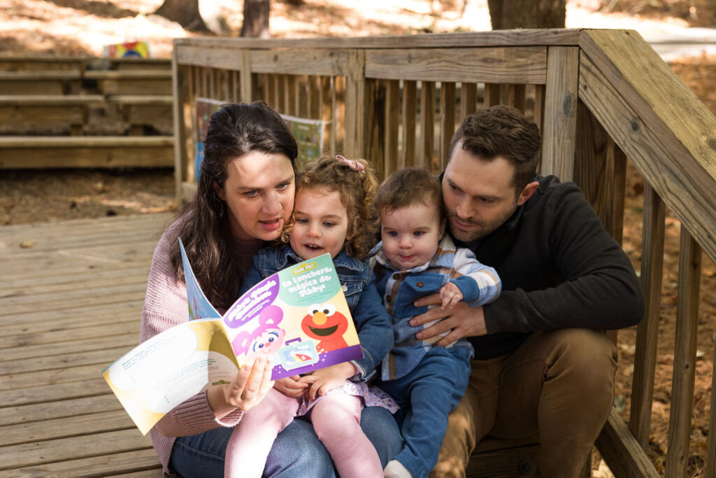 Family reads a book by little free library at Prairie Ridge Ecostation during photo session