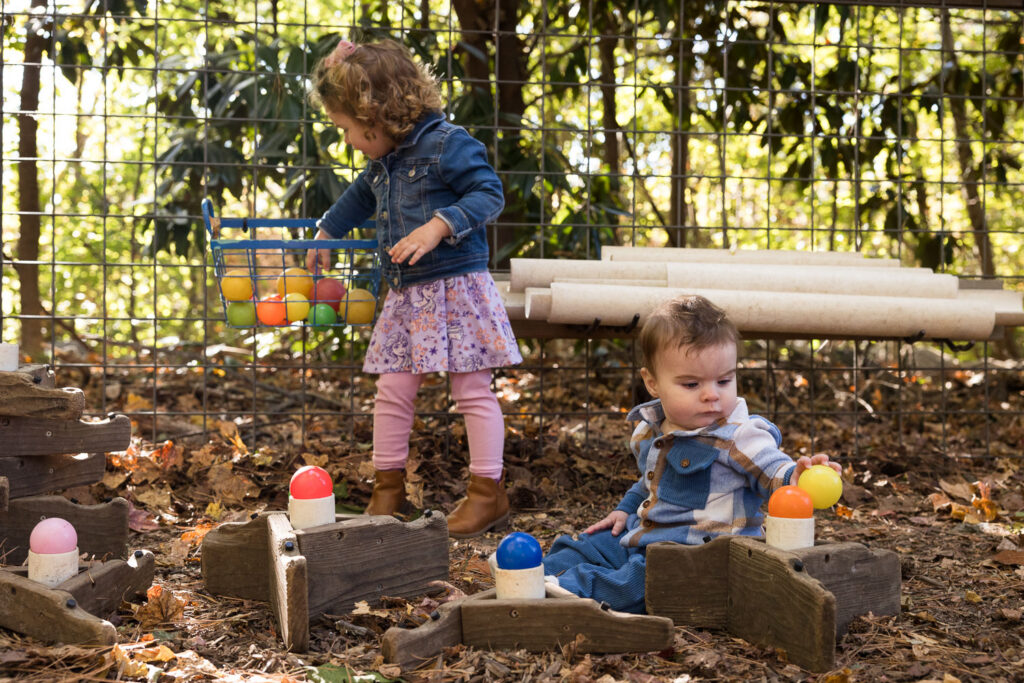 Candid documentary family photos at Prairie Ridge Ecostation Raleigh, toddler and baby brother play with balls and ramps
