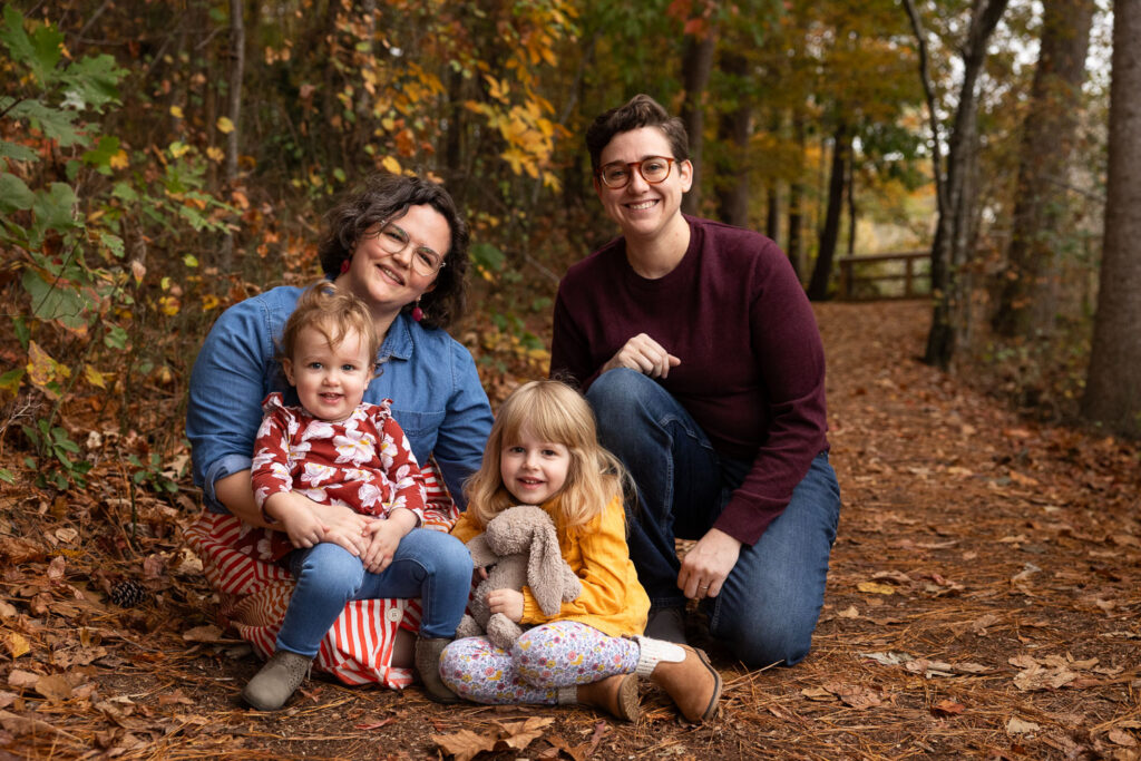 Raleigh fall mini-session with family of four with two moms at Historic Yates Mill County Park in fall foliage with an autumn color scheme for coordinated clothes