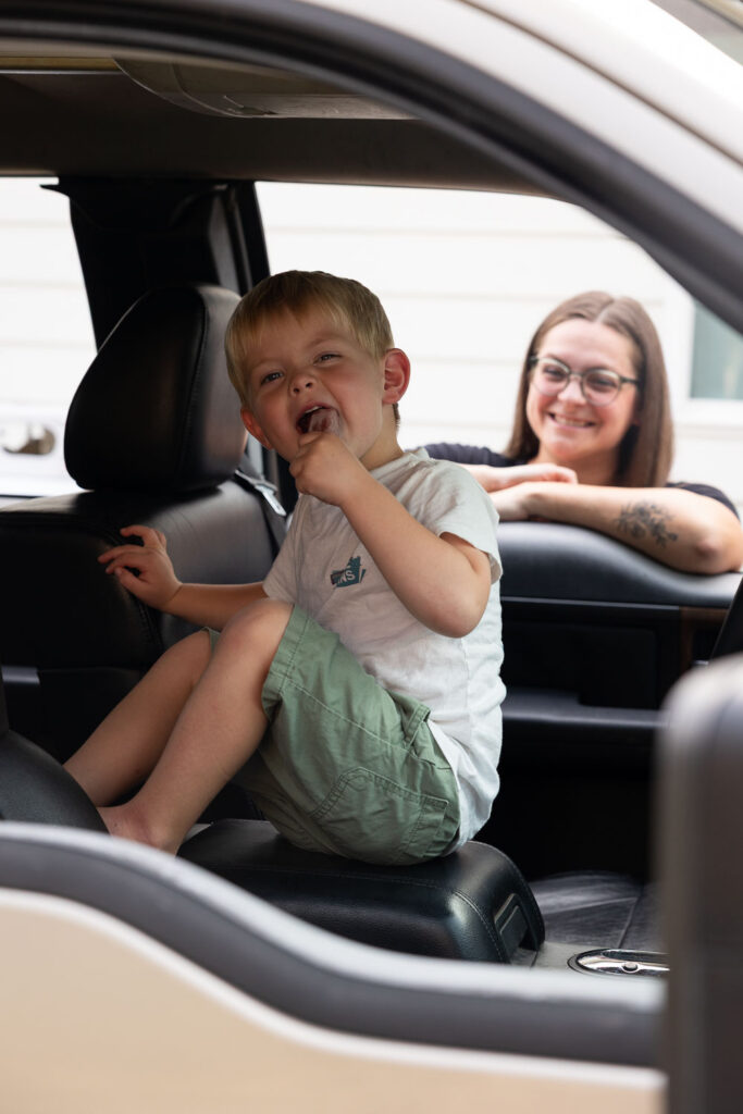 Young boy sitting in the family truck during a summer evening family photo session in Holly Springs, NC.